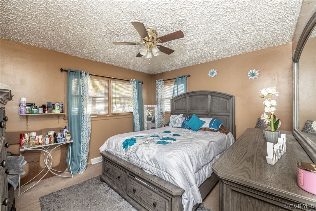 Primary bedroom with ceiling fan and overhead ligh