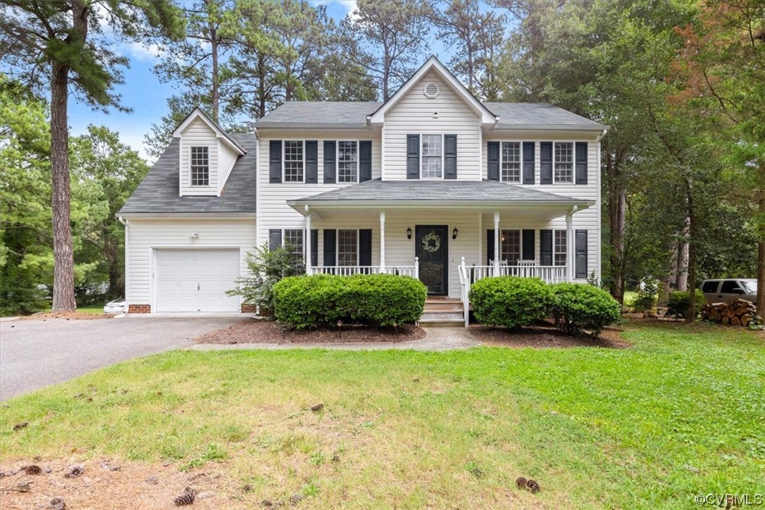 Front view with covered front porch, paved drivewa
