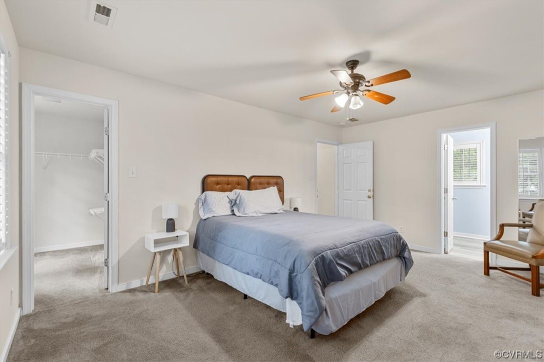 Primary Bedroom with walk-in closet, ceiling fan,