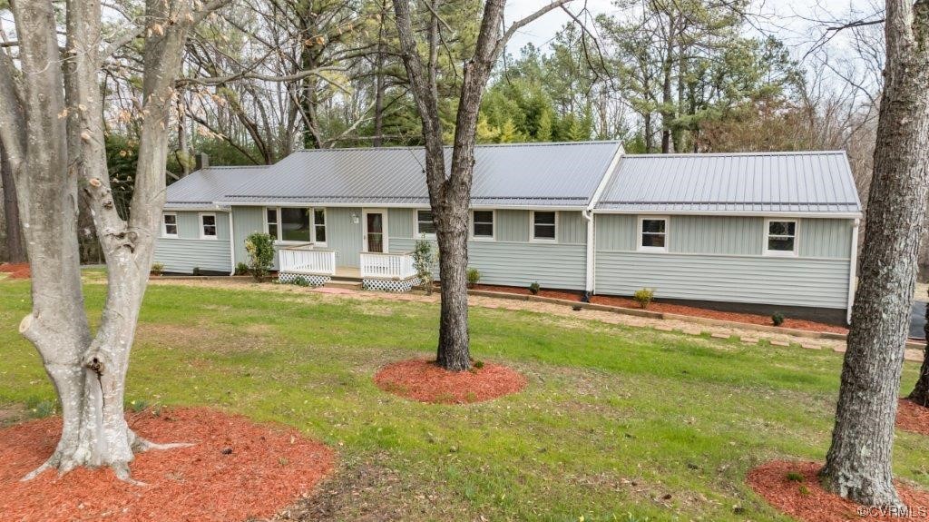 Ranch-style home featuring a front lawn