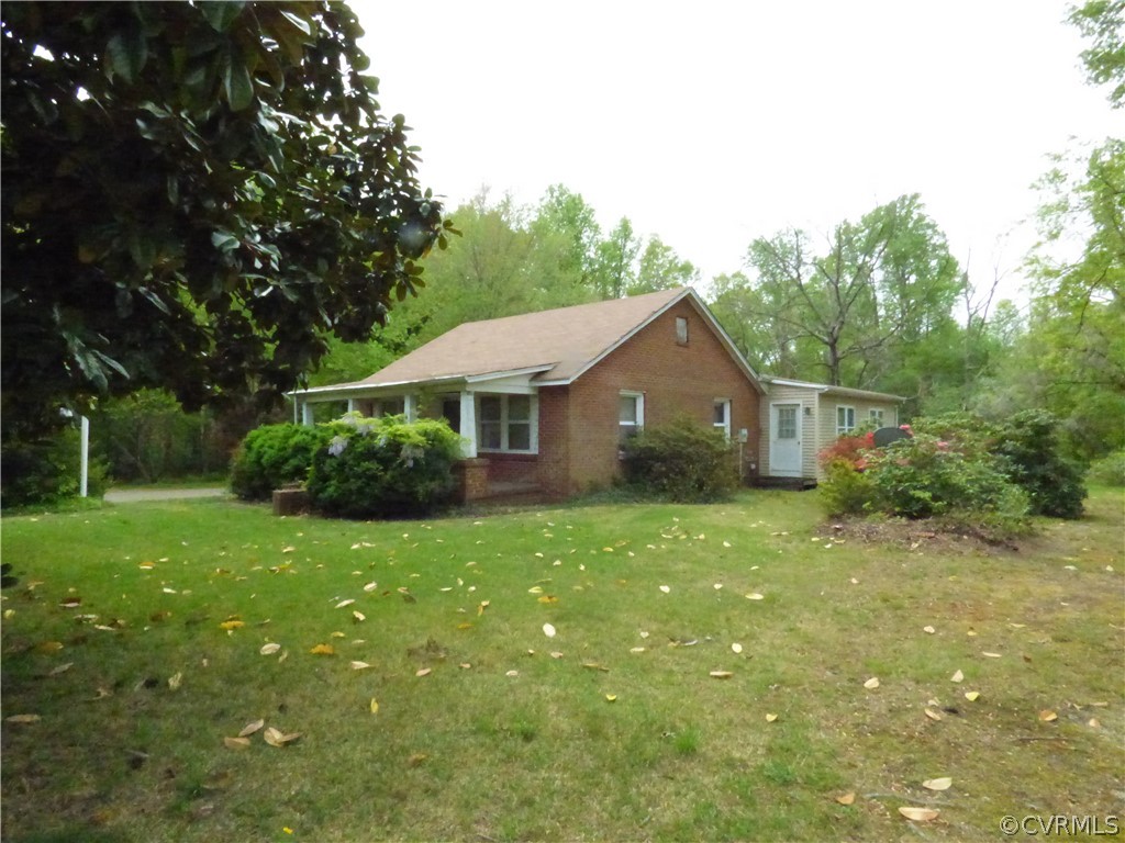 Ranch-style home featuring a front lawn