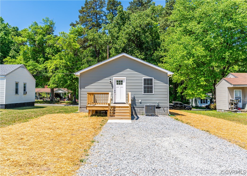Rear view of house featuring a yard and central AC