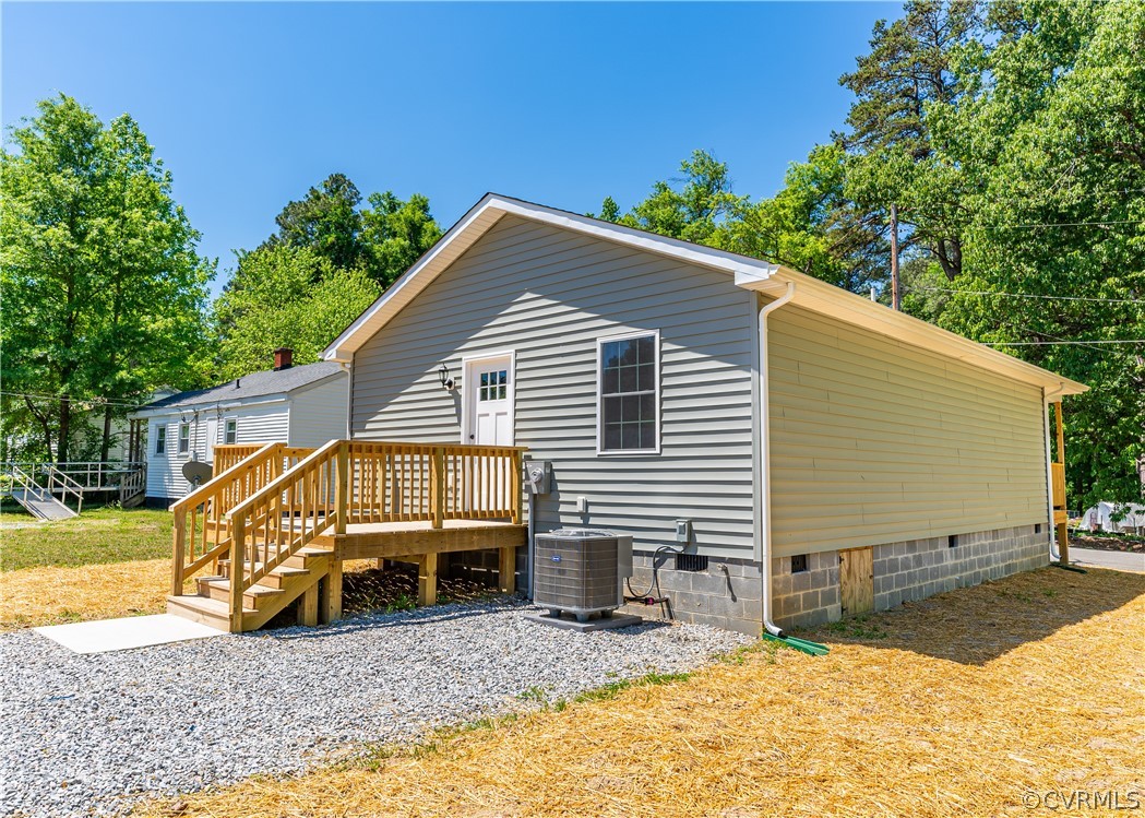 Back of property featuring a wooden deck and centr