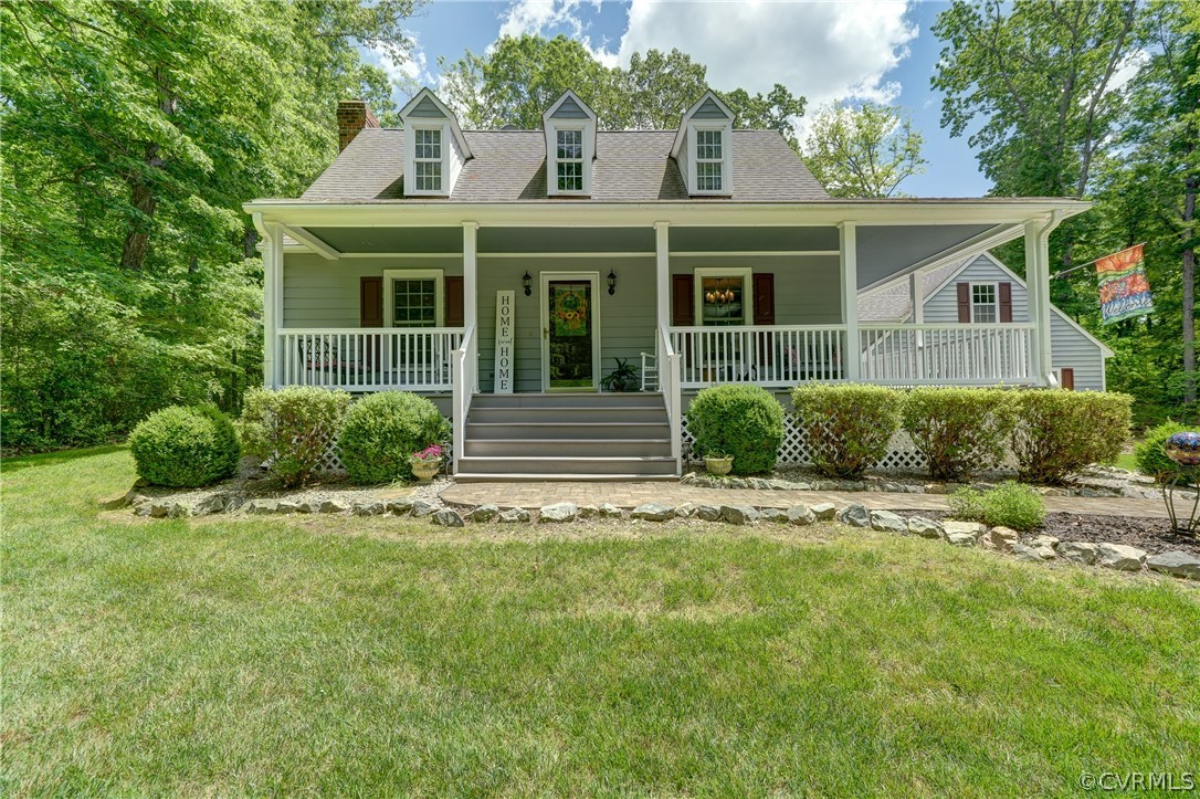 New england style home featuring a front lawn and
