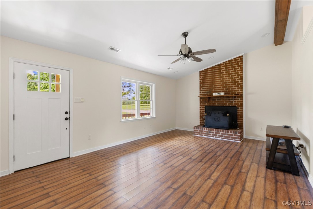 Unfurnished living room featuring ceiling fan, dar