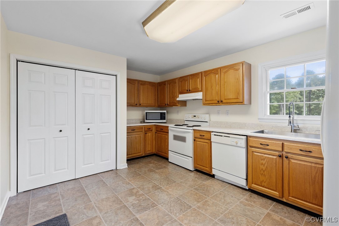 Kitchen featuring white appliances and sink
