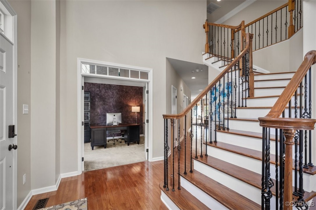 Entrance foyer featuring crown molding, a towering