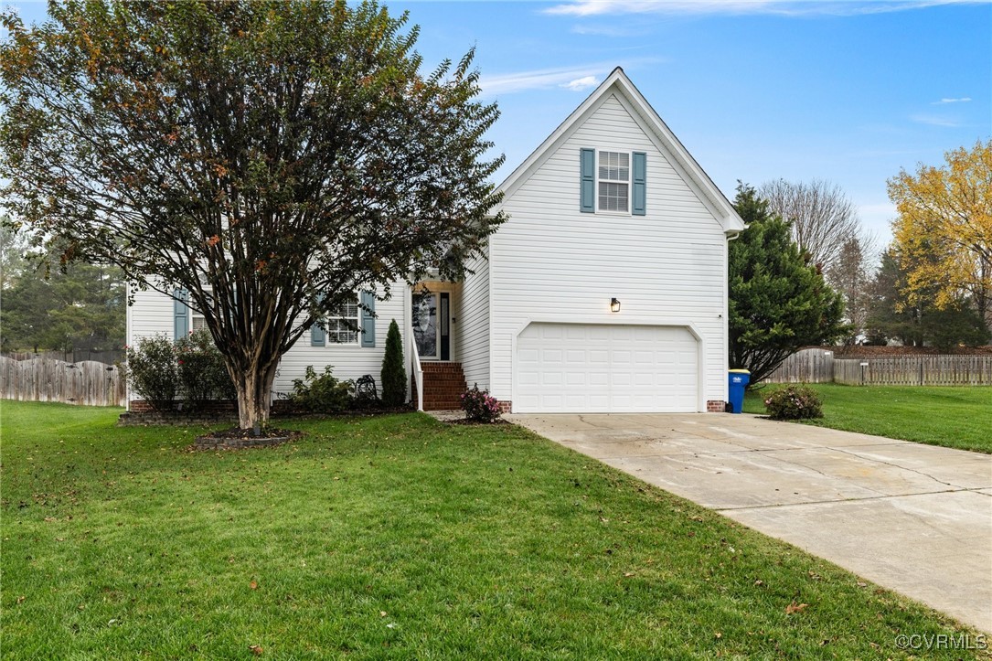View of front property with a front yard and a gar