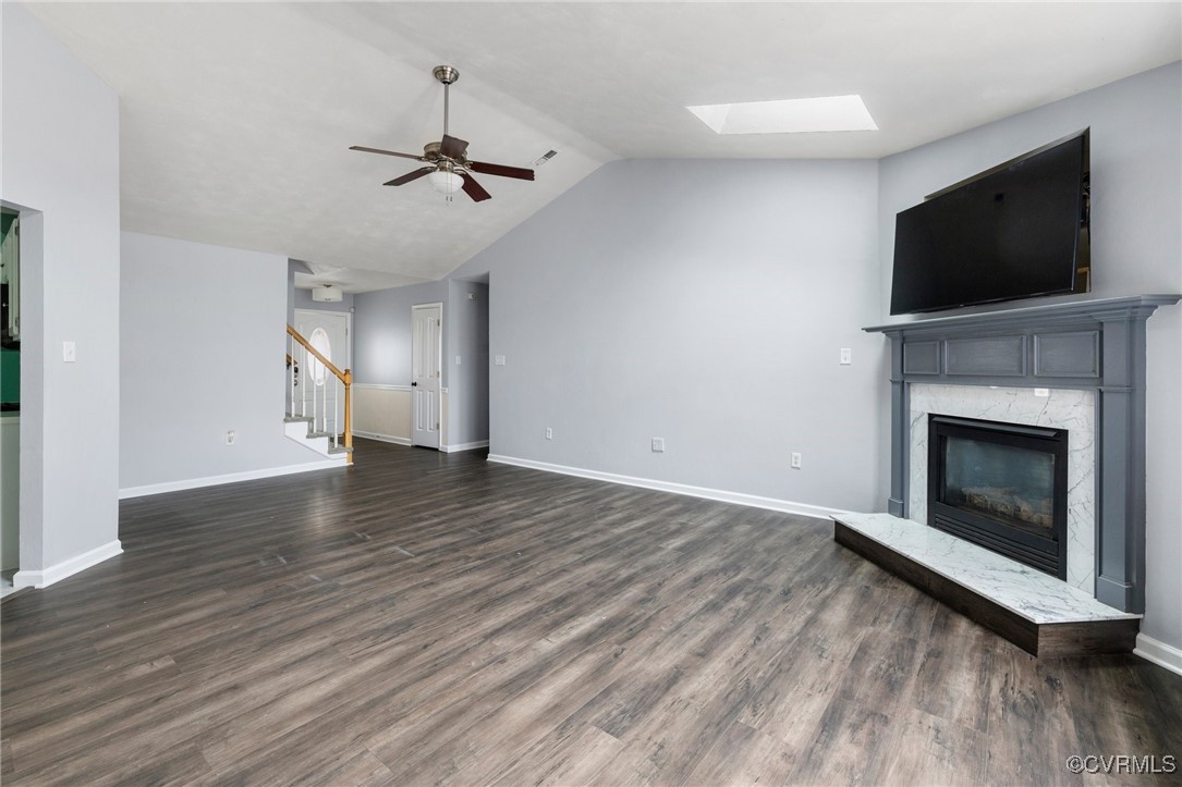 Unfurnished living room featuring ceiling fan, dar