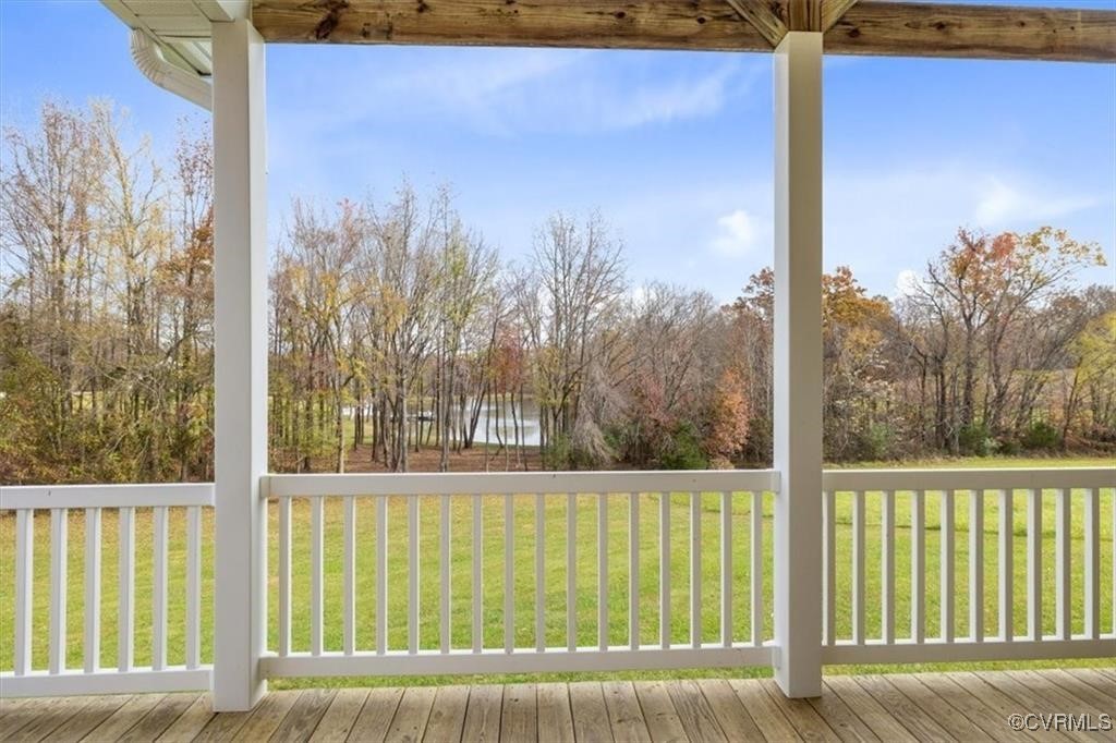 Wooden terrace with a water view and a lawn