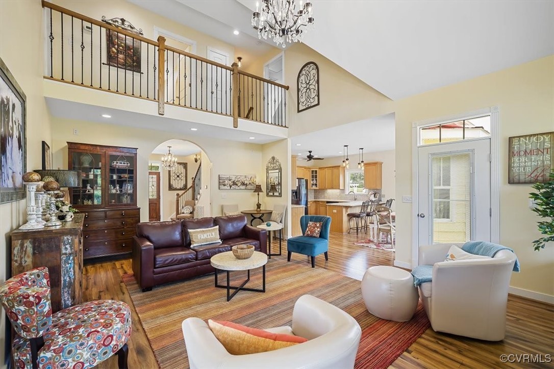 Living room with ceiling fan with notable chandeli