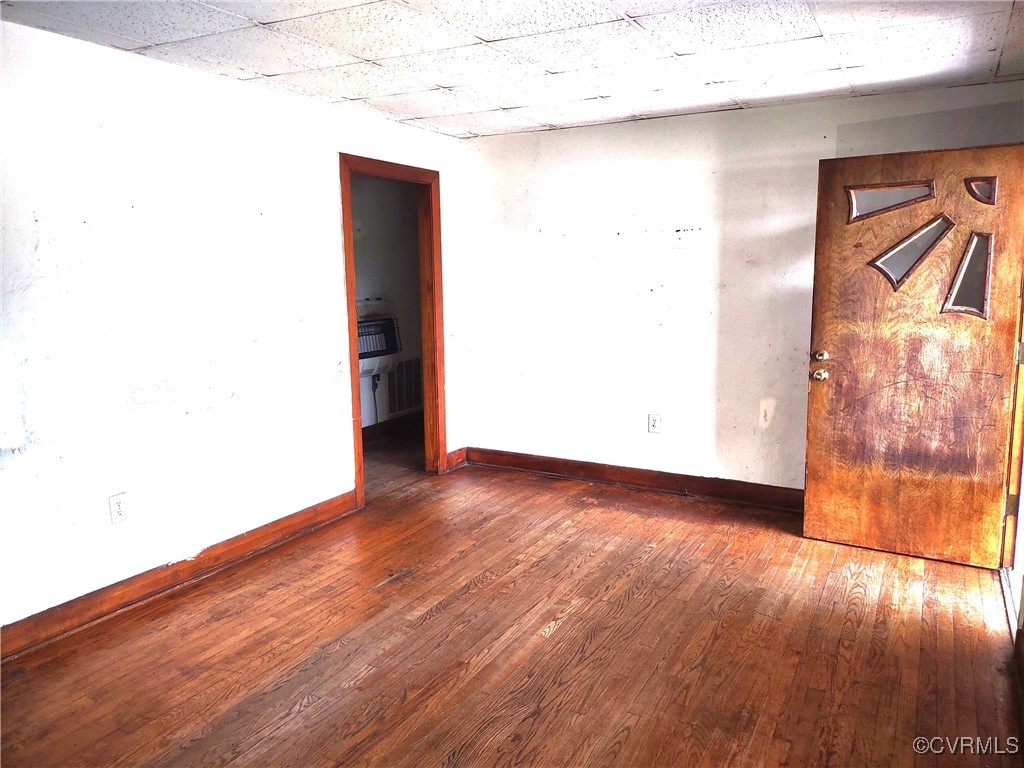 Spare room with baseboards, hardwood / wood-style