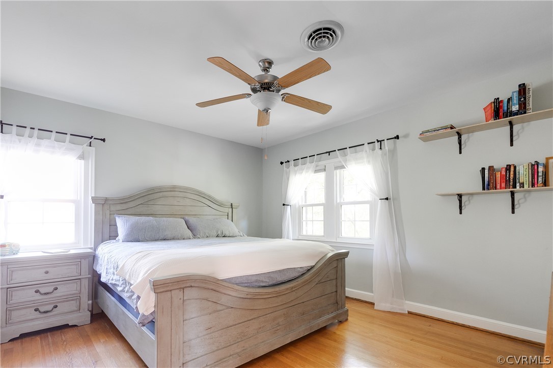 Primary bedroom with ceiling fan, 3 windows, & clo