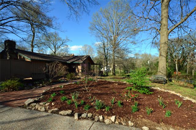 The lot is wooded and extensively landscaped, with brick sidewalks and terraces.