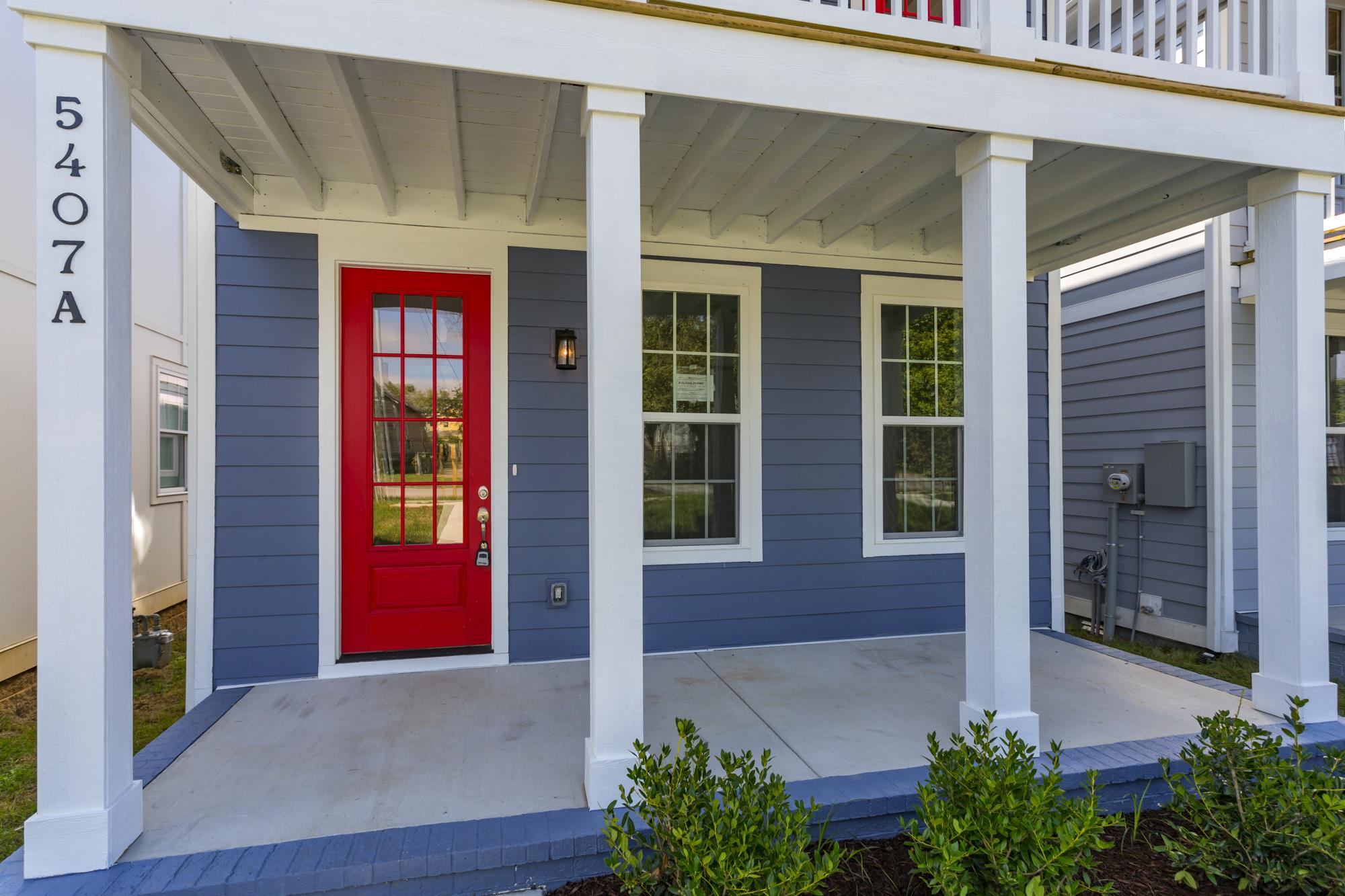 Gorgeous front porch and a stunning red hardwood front door! 