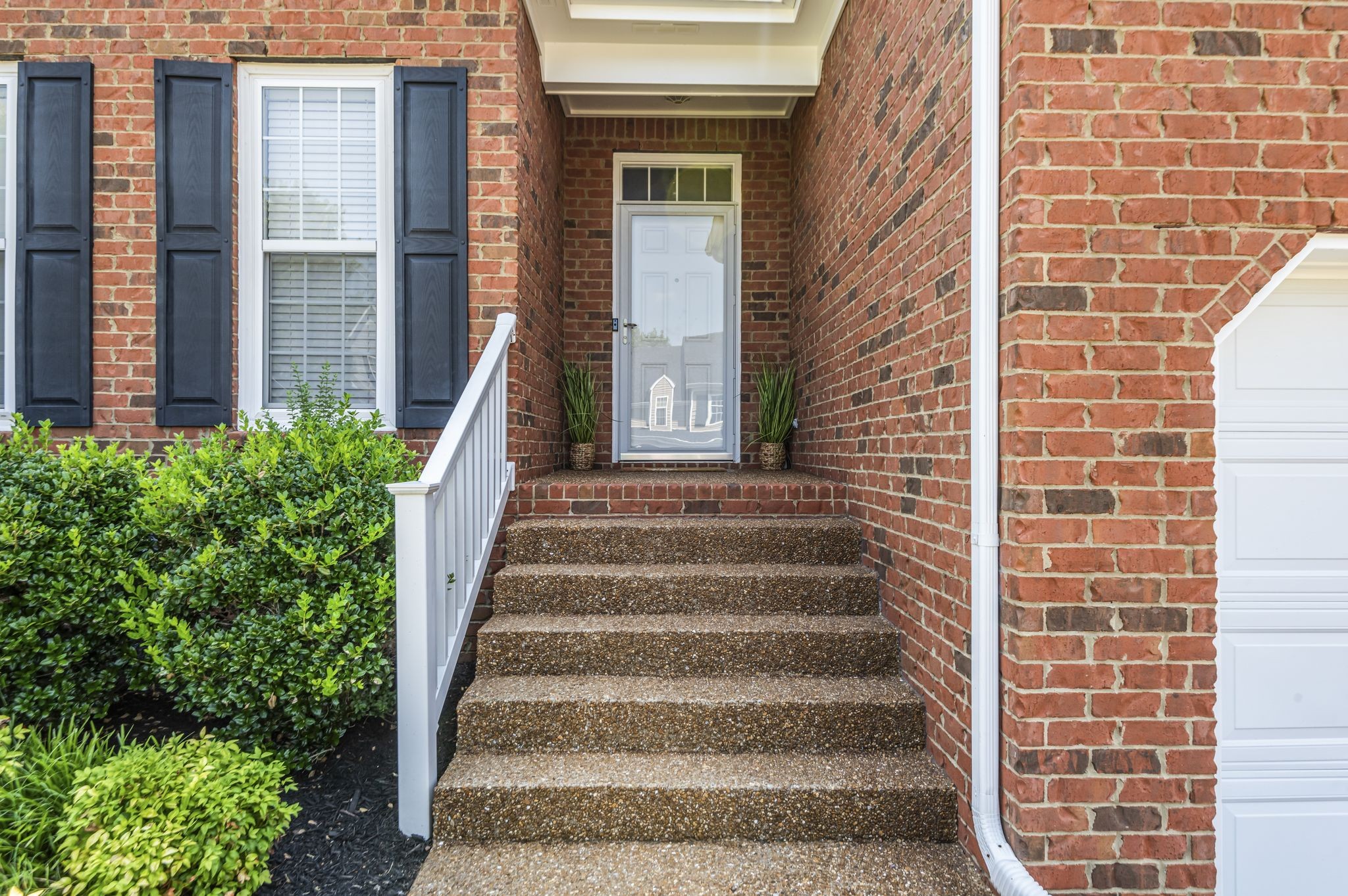 Elegant aggregate steps lead to the doorway of this gorgeous home.